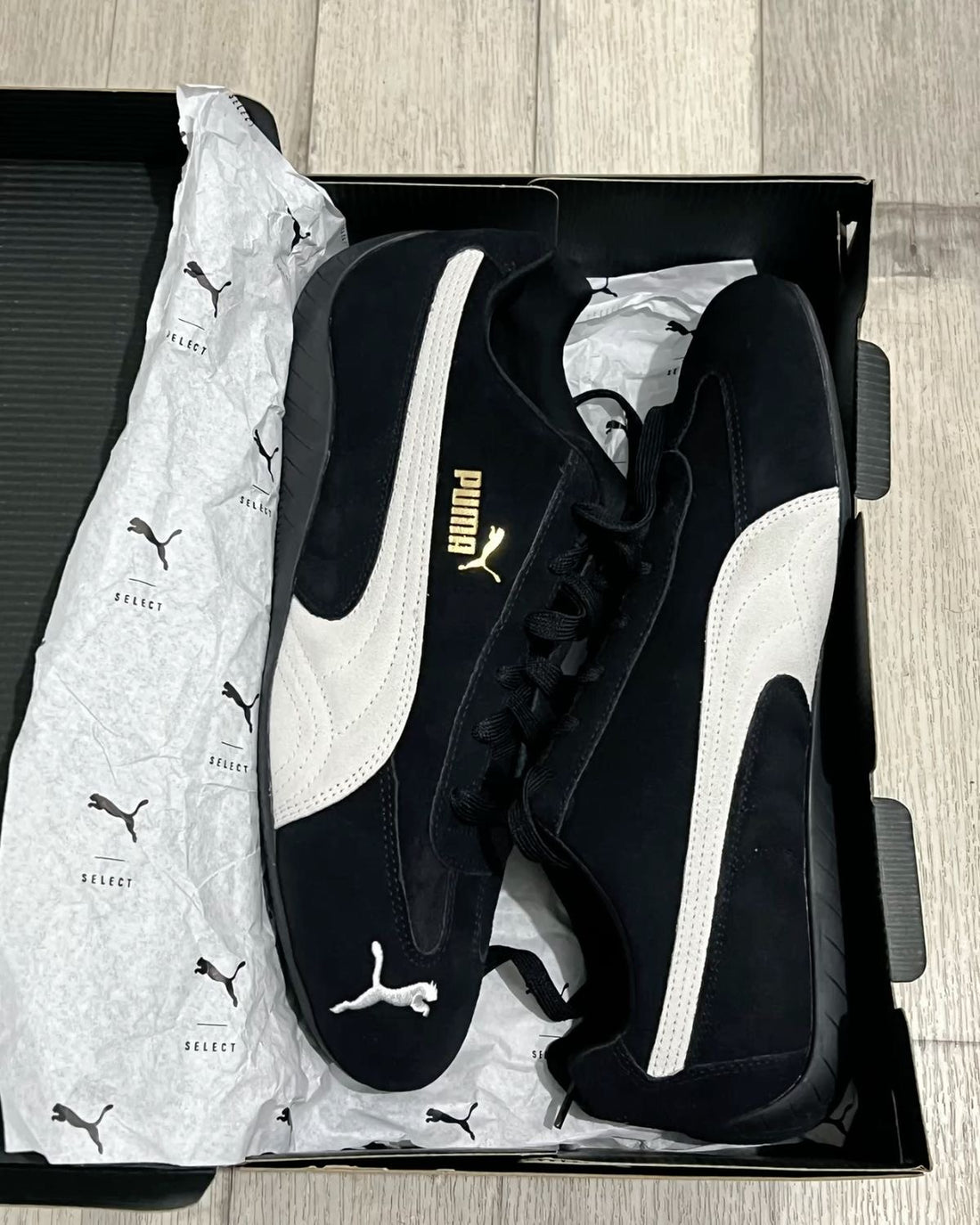 Black and white Puma sneakers in their box